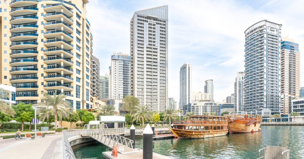 Stunning view of Dubai Marina with luxury buildings, wooden boats, and a calm waterfront.