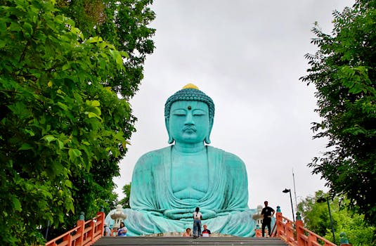 Impressive Giant Buddha statue in Thailand, framed by lush trees, showcasing serene beauty.